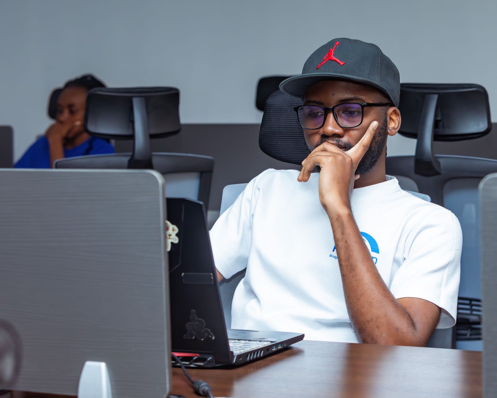 A man thinking at his laptop in an office