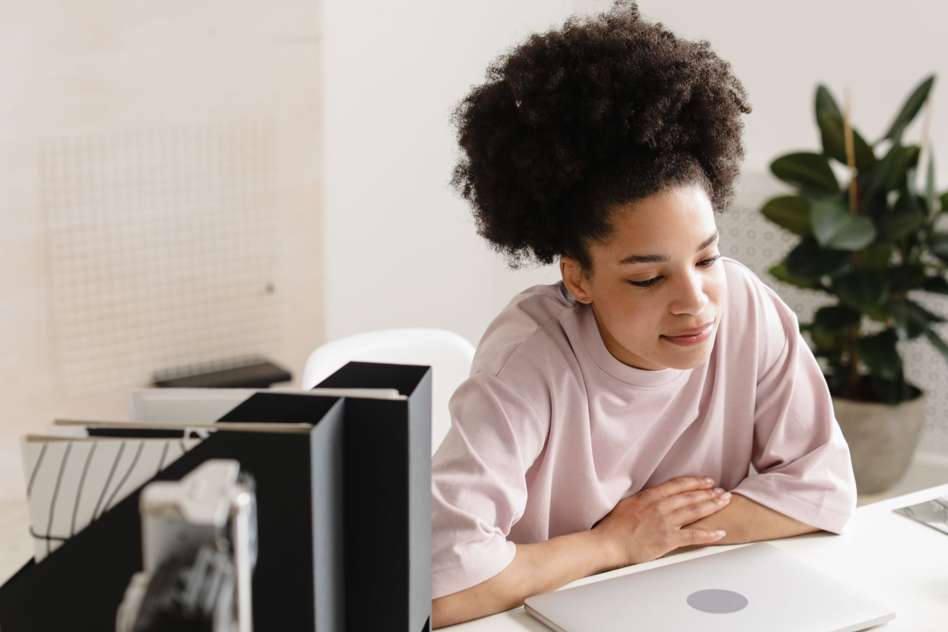 A woman at a desk looking at a laptop