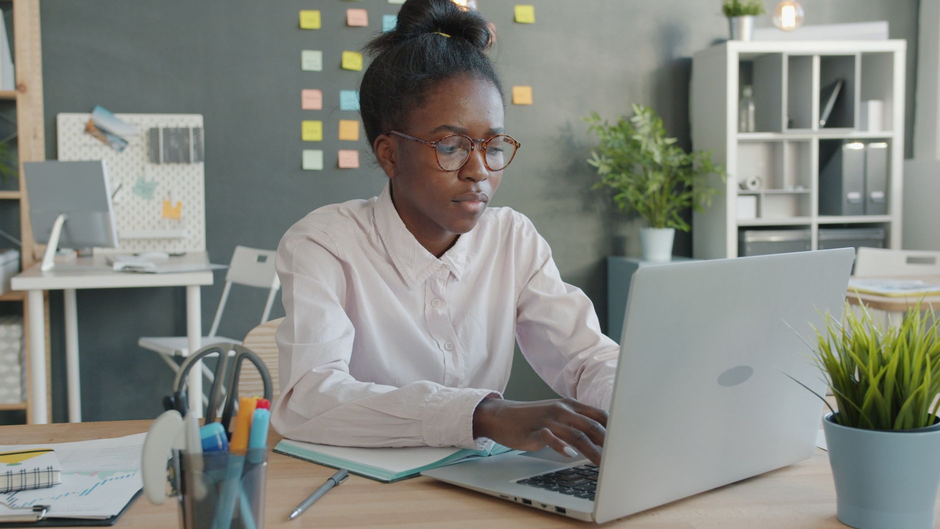 A woman working at a laptop in an office